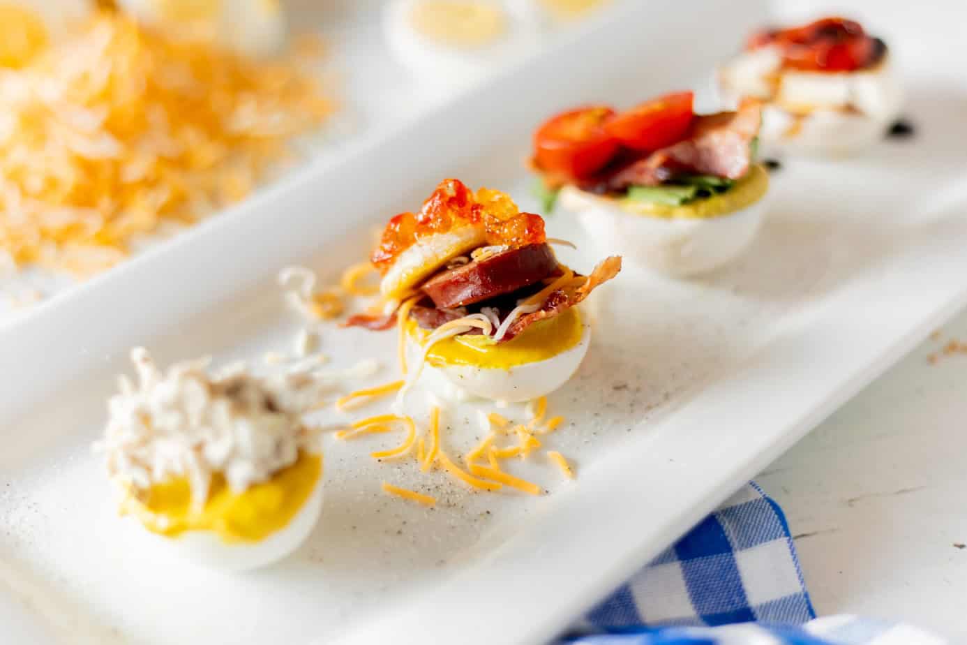 breakfast egg flight with mayo, mustard, bacon, sausage, cheese, mini pancake, pepper jelly