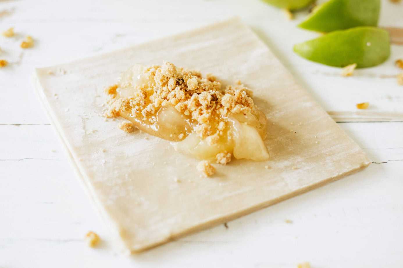 apple pie filling on an egg roll wrap with struesel on top