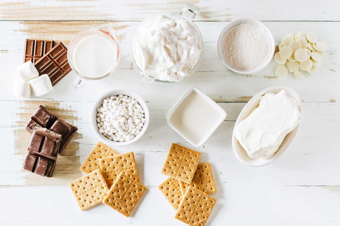 frozen smores bars ingredients on a white wooden surface