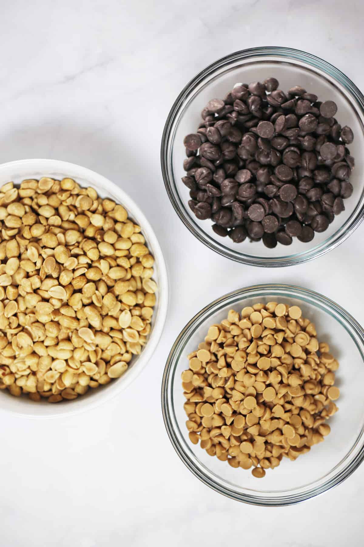 semi-sweet chocolate chips, peanut butter chips and salted peanuts in individual bowls