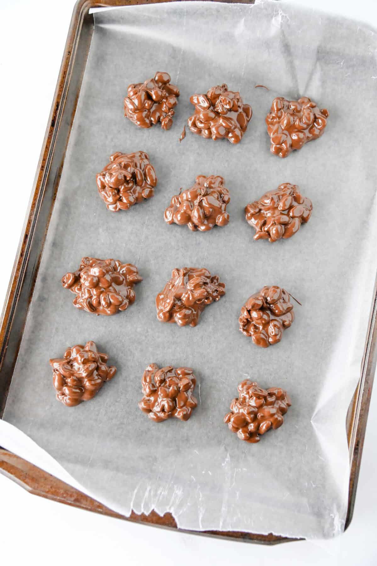 peanut clusters on a parchment lined cookie sheet