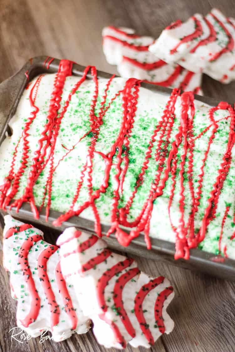 finished frozen pan of Little Debbie Christmas Tree Cakes Ice Cream with red candy melts drizzled and green sanding sugar on top