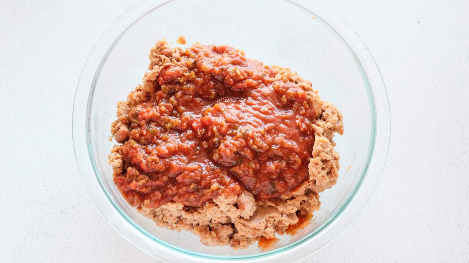 refried beans and salsa in clear bowl