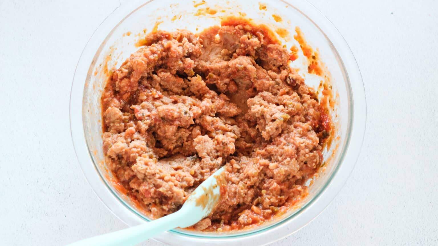 refried beans and salsa mixed in clear bowl
