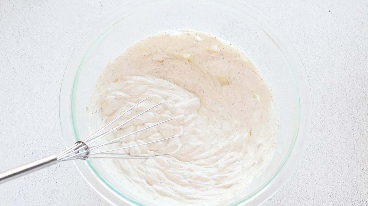 sour cream and ranch dressing mix in a clear bowl