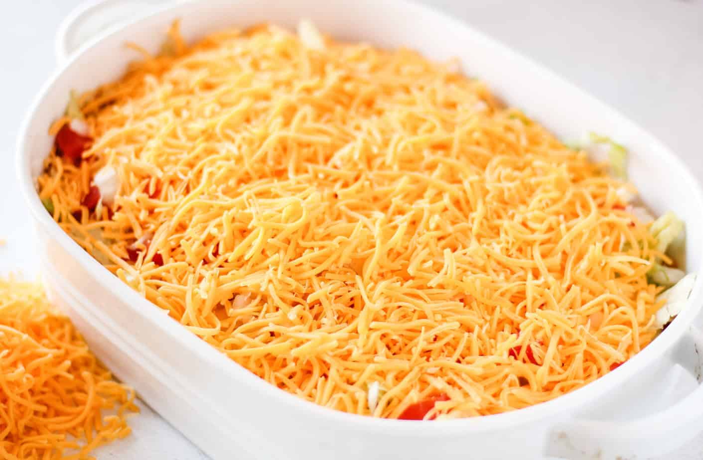 layered taco dip in an oval baking dish