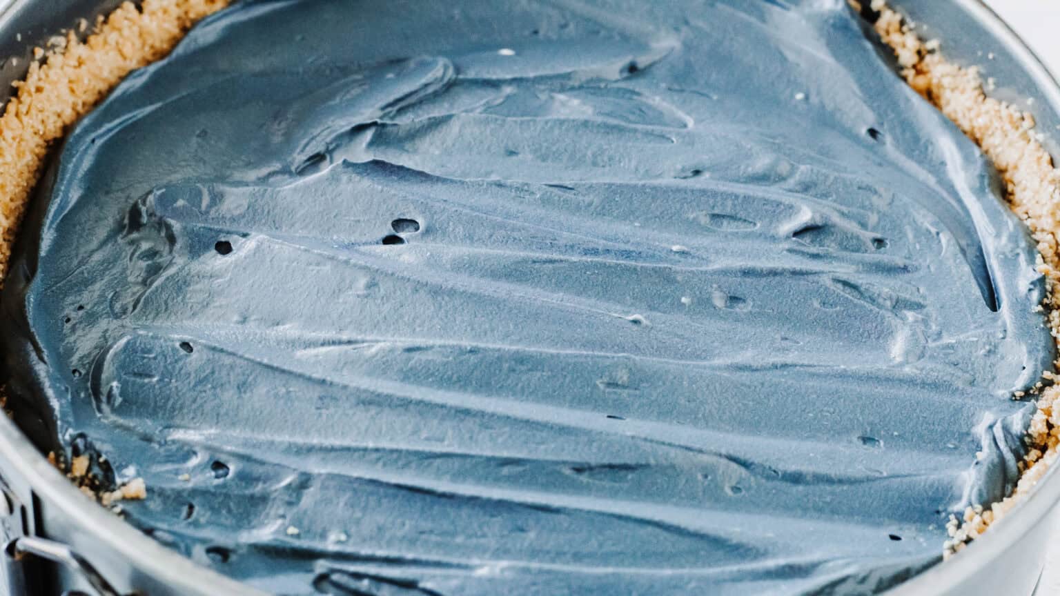 black cheesecake smoothed in springform pan
