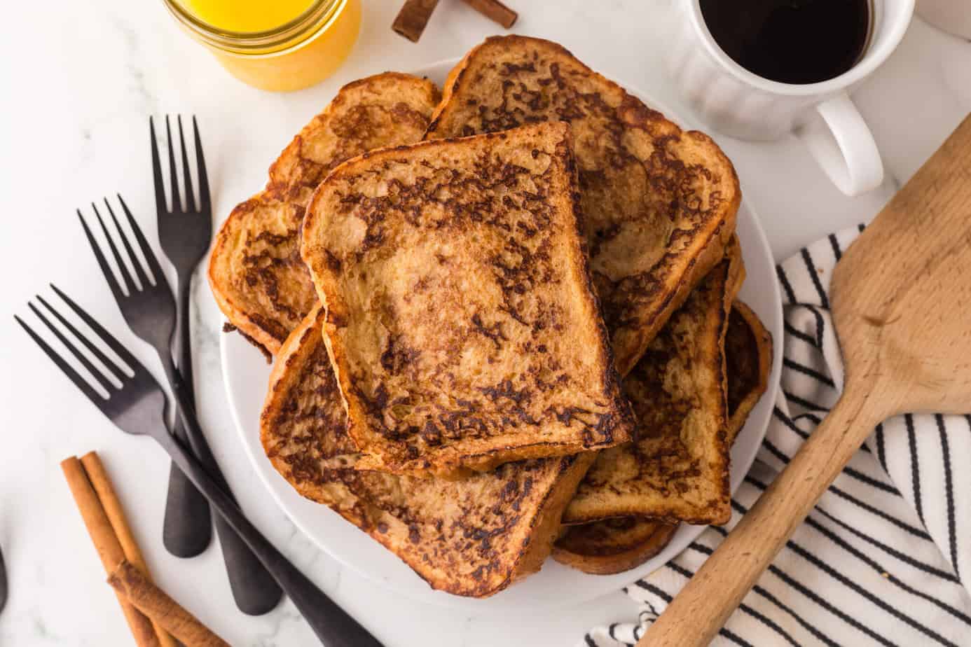 a stack of french toast on a plate with syrup next to it