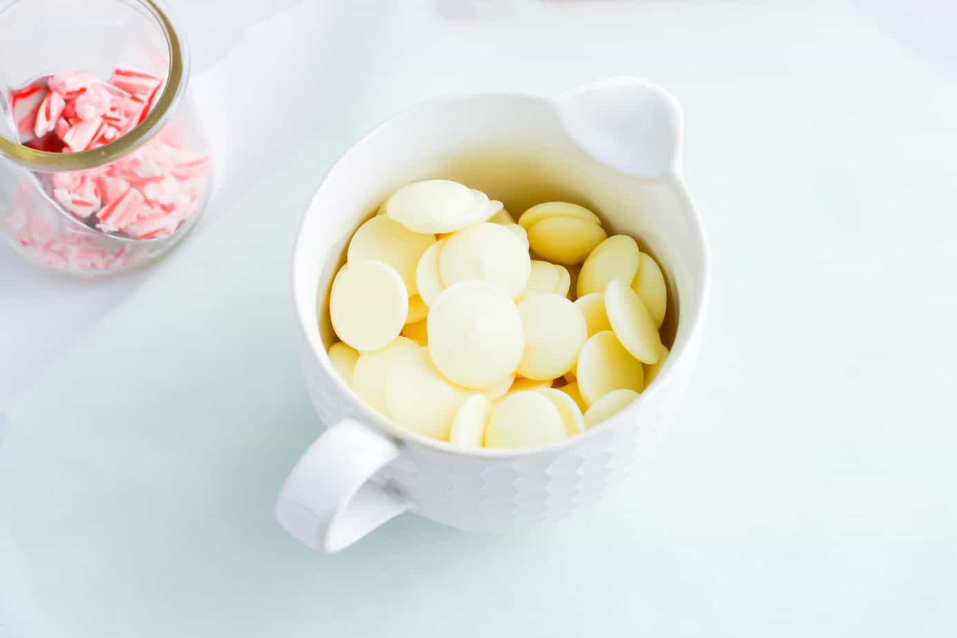 white chocolate melting wafers in a white cup