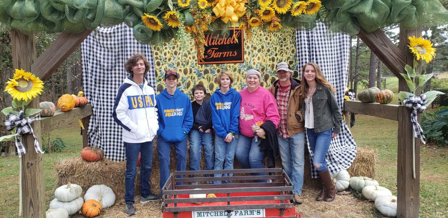 family at pumpkin patch photo op