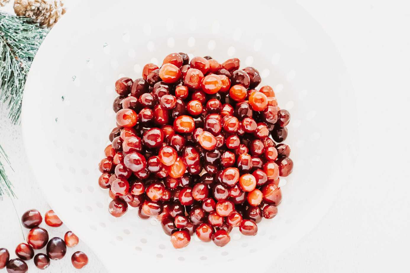 syrup coated cranberries in a strainer