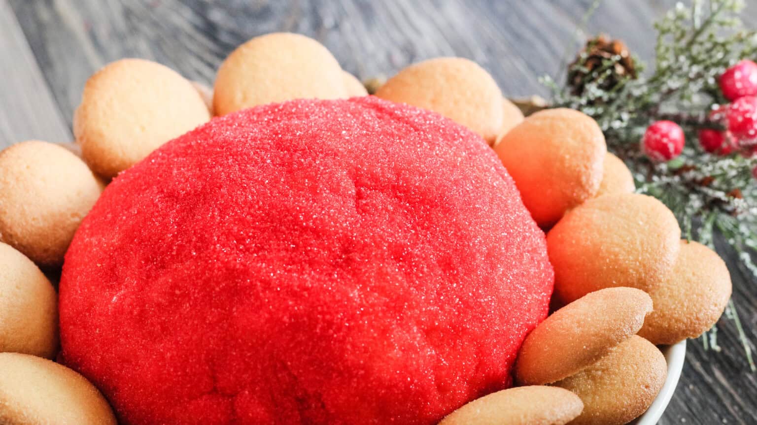 cheeseball covered in red sugar with vanilla wafers surrounding it