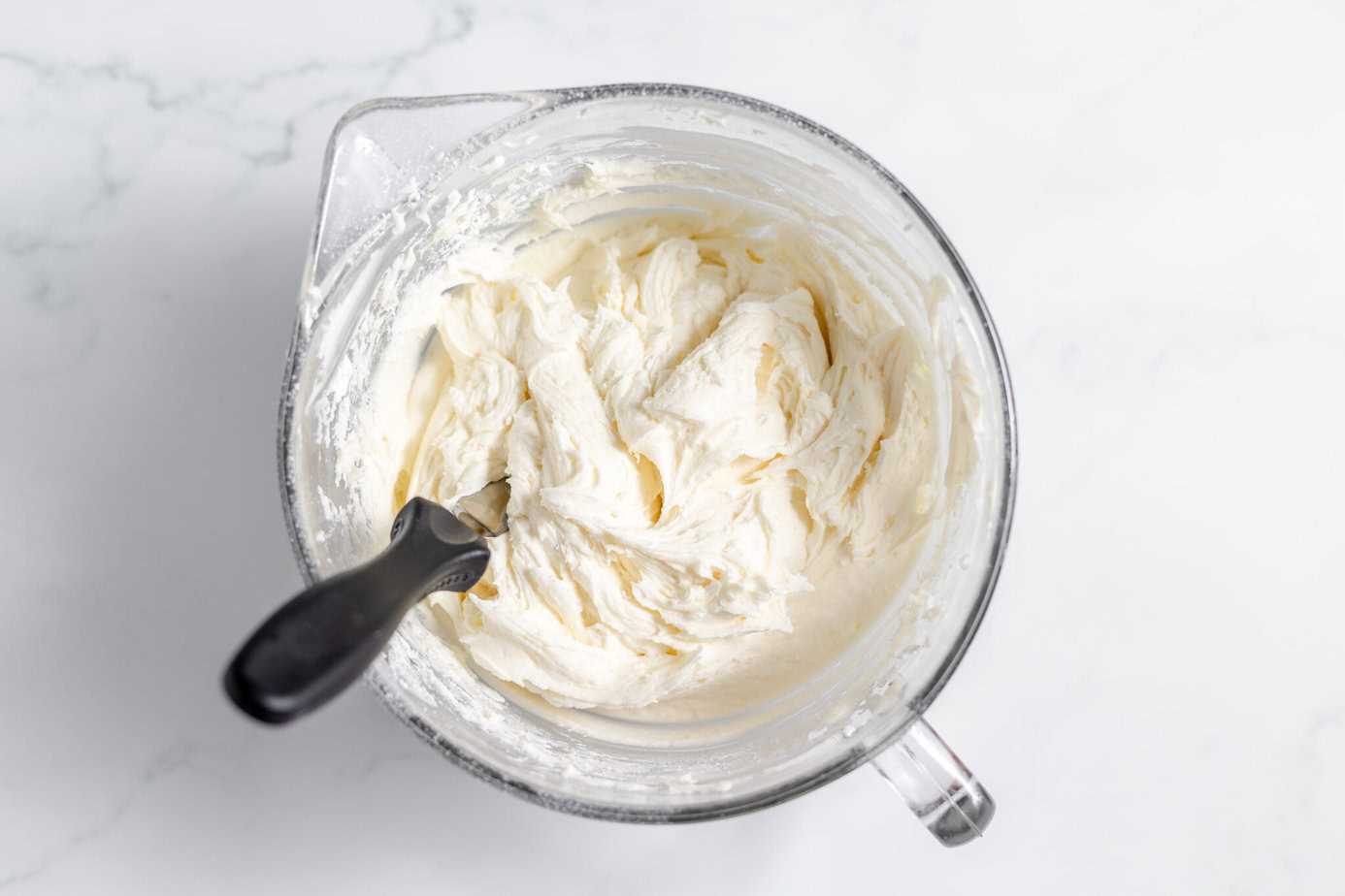 cream cheese frosting in clear mixing bowl