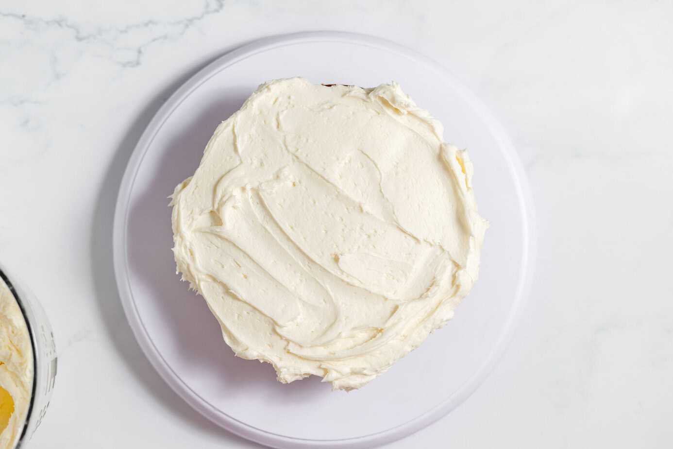 cream cheese frosting spread on layer of italian cream cake