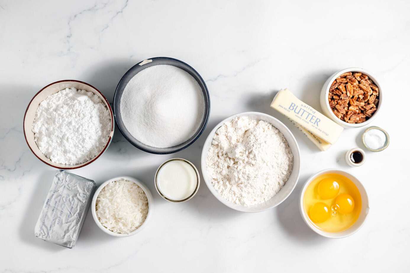 italian cream cake ingredients in bowls on white surface