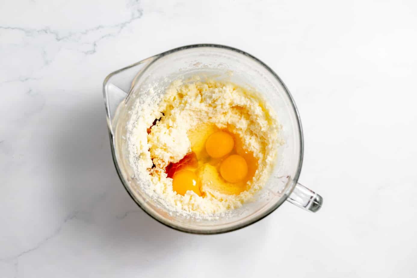 dry ingredients in clear bowl with butter and eggs