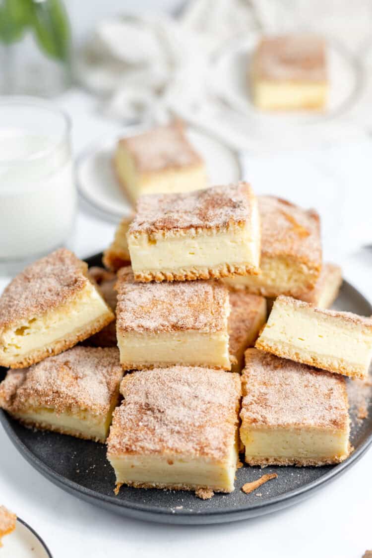 churro cheesecake bars stacked on a plate