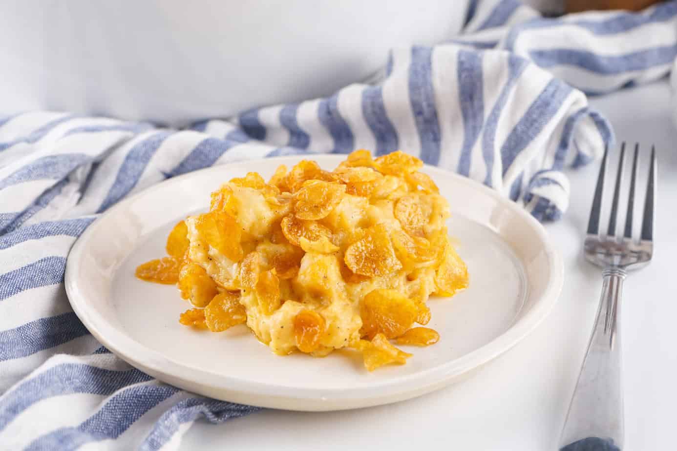 Crockpot Funeral Potatoes on a white plate with a fork