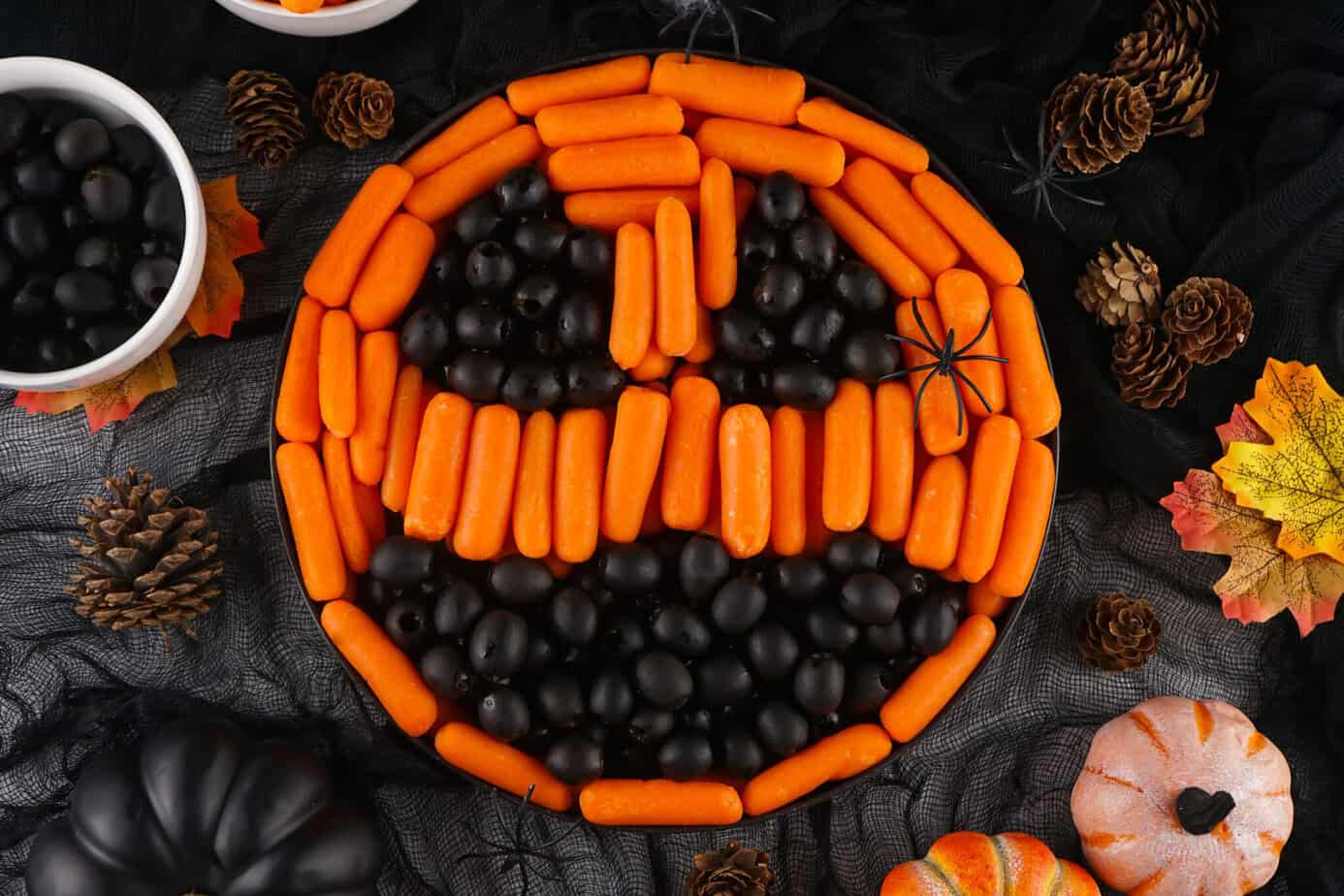Finished Halloween Veggie Tray with carrots and black olives that looks like a Pumpkin Jack-O-Lantern face
