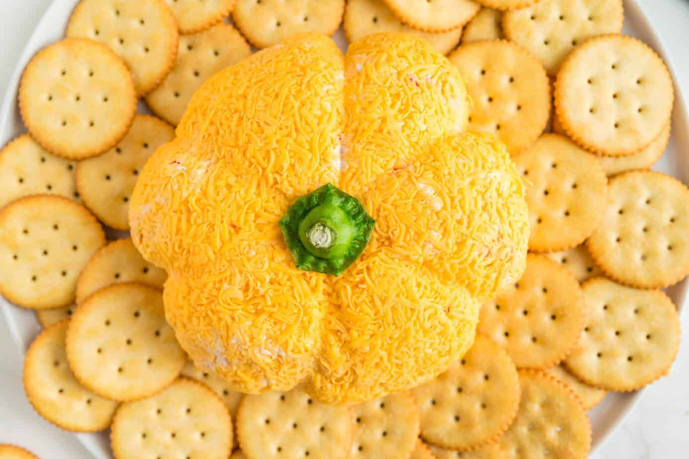 Pumpkin Shaped Cheese Ball on a plate surrounded by crackers