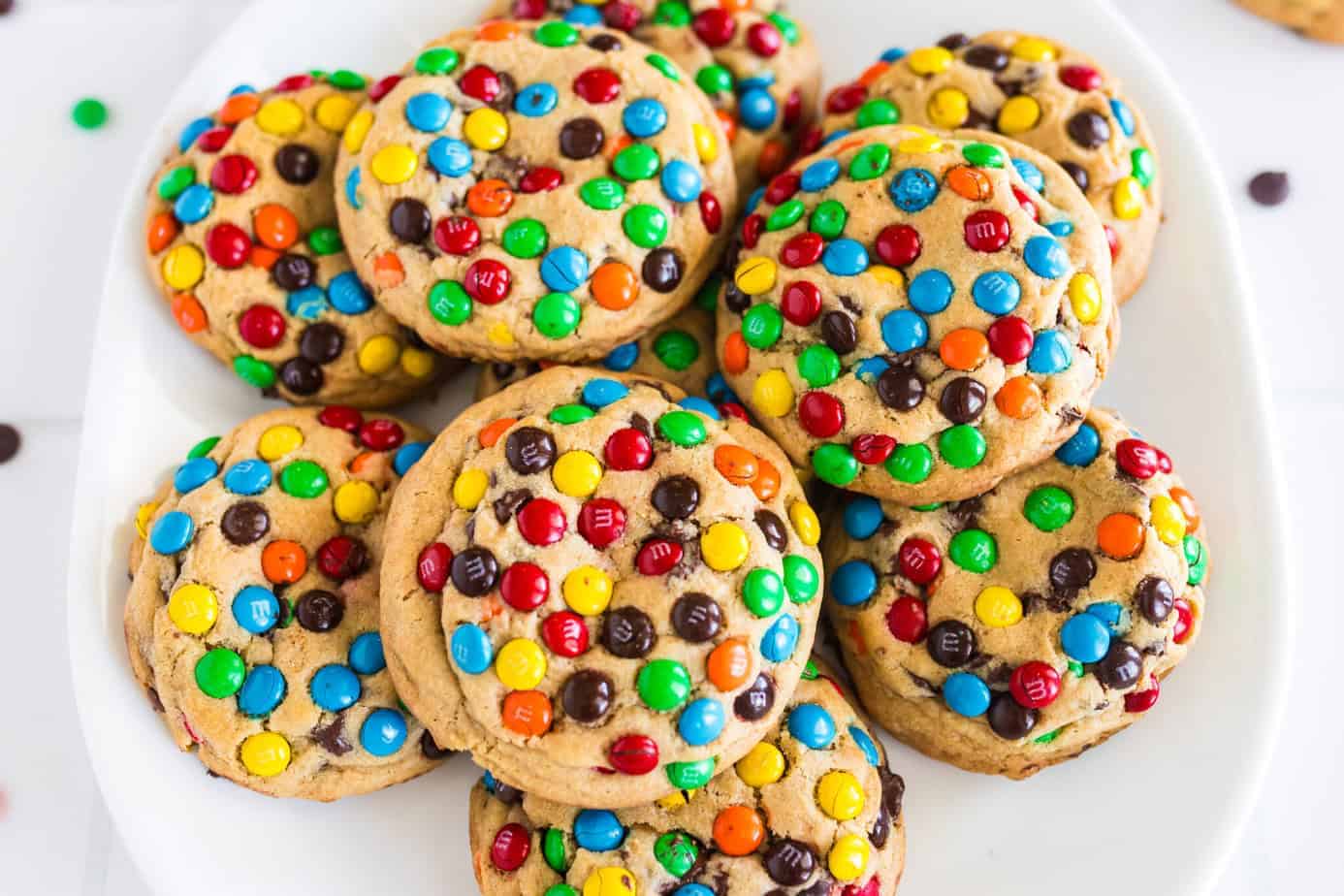 Chocolate M&M Cookies stacked on a white plate