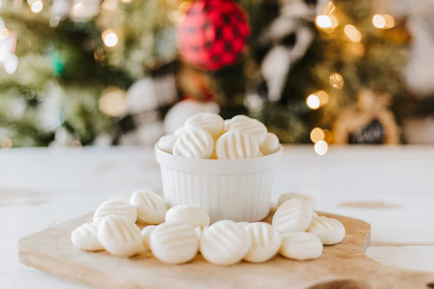 cream cheese mints in a white bowl on a cutting board