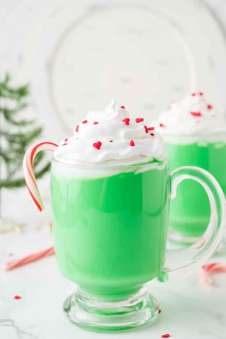 grinch hot chocolate with a candy cane in a glass