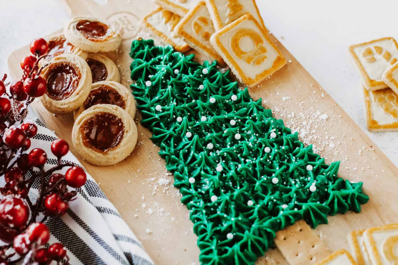 Christmas Buttercream Board in the shape of a Christmas Tree surrounded by cookies