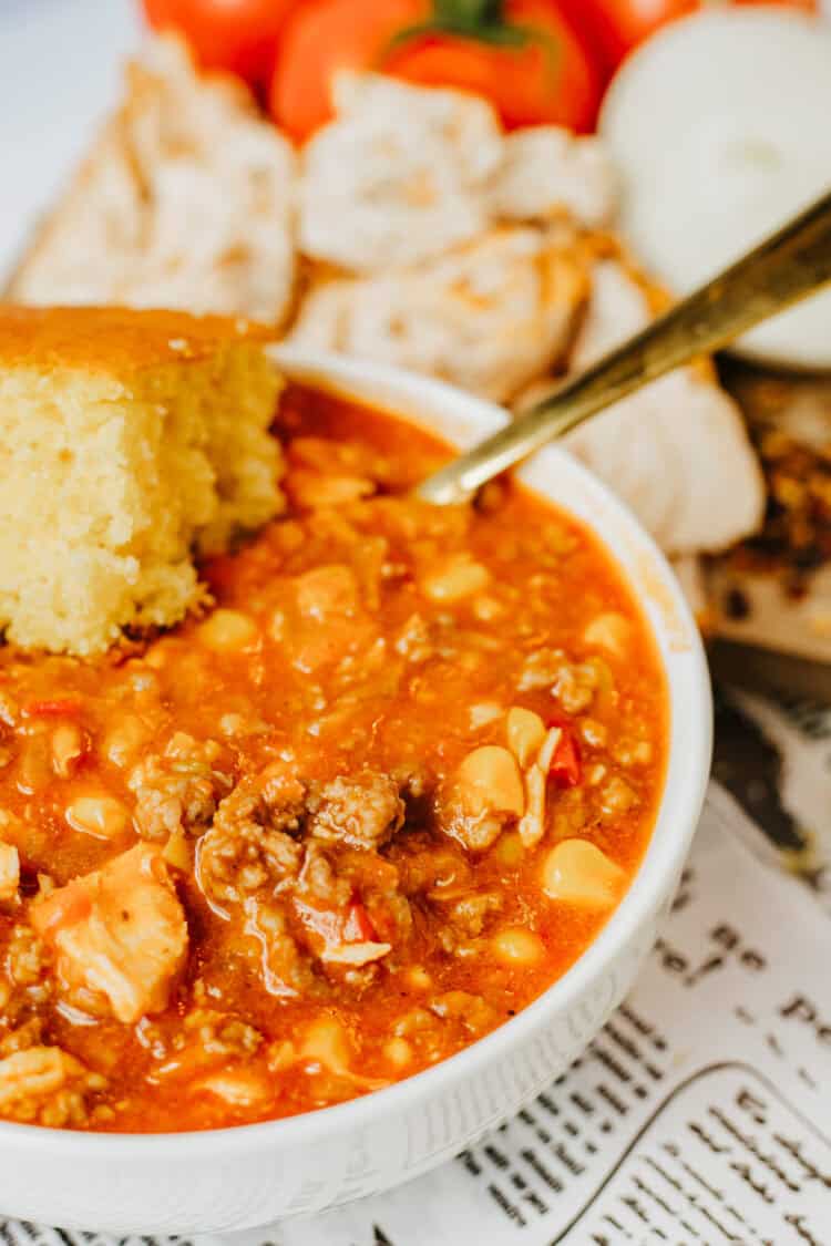 brunswick stew - copycat smokey bones recipe with cornbread in a white bowl