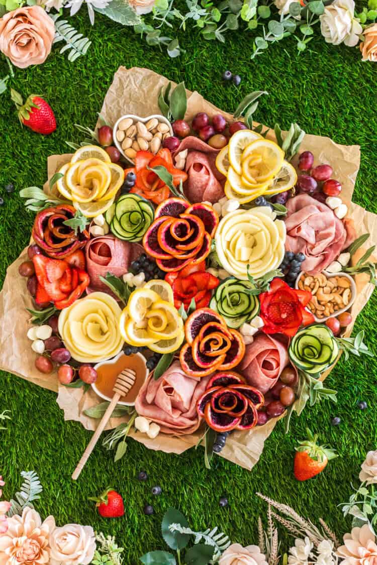 spring charcuterie board with charcuterie flowers made of meat, cheese, fruit and veggies