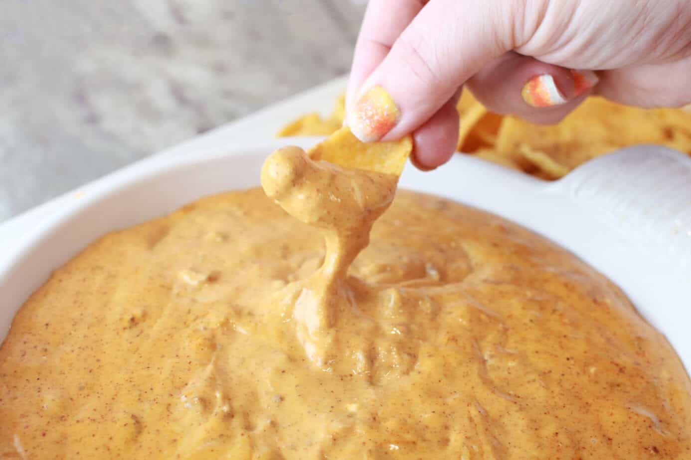 fritos scoops dipping into chili cheese dip