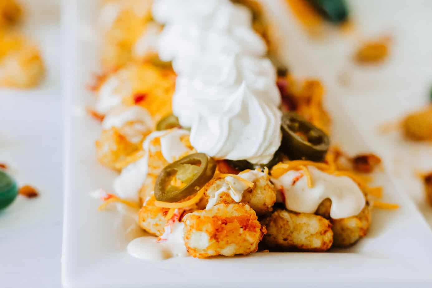 loaded tater tots on a white platter