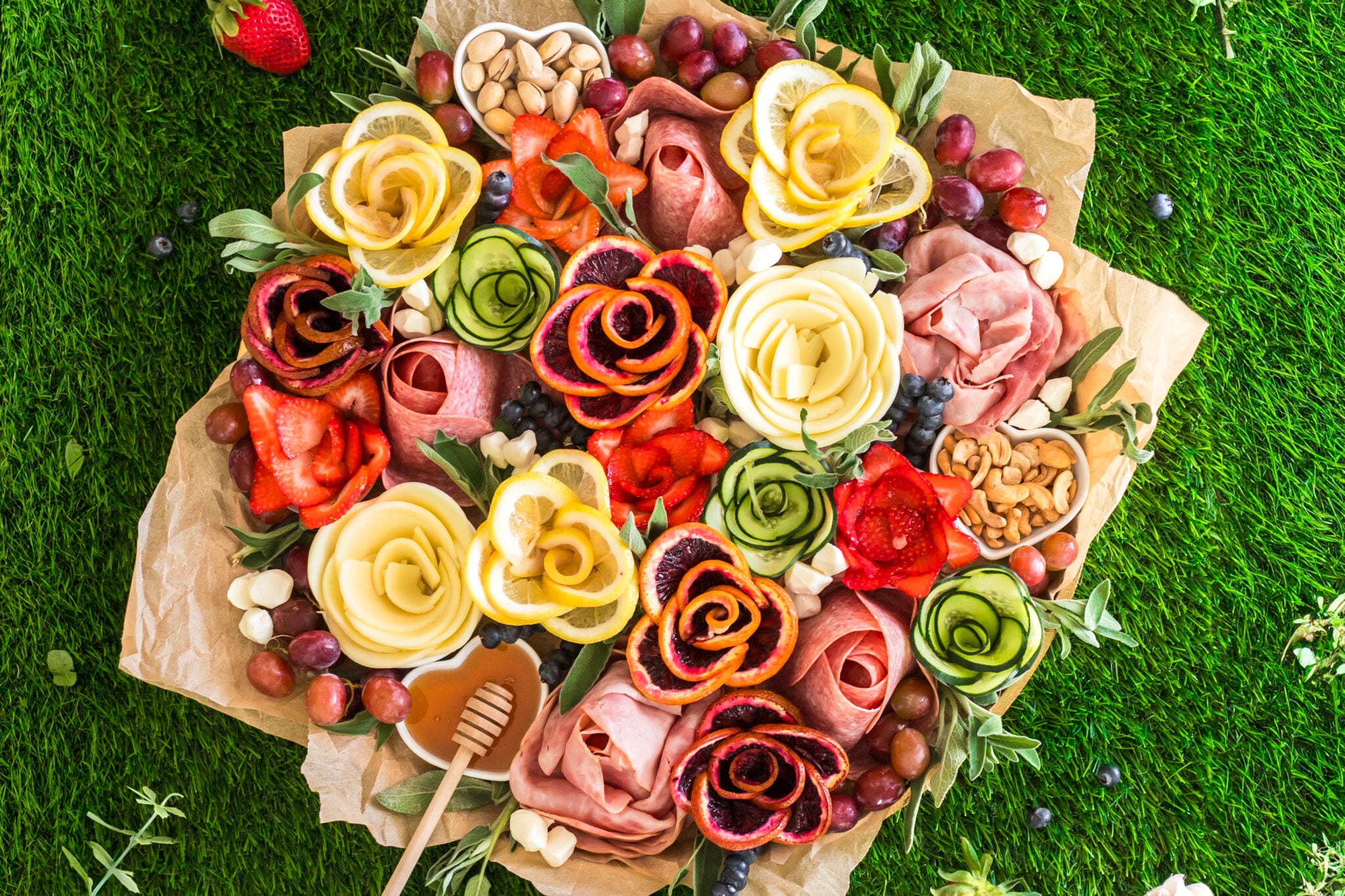 spring charcuterie board with charcuterie flowers made of meat, cheese, fruit and veggies