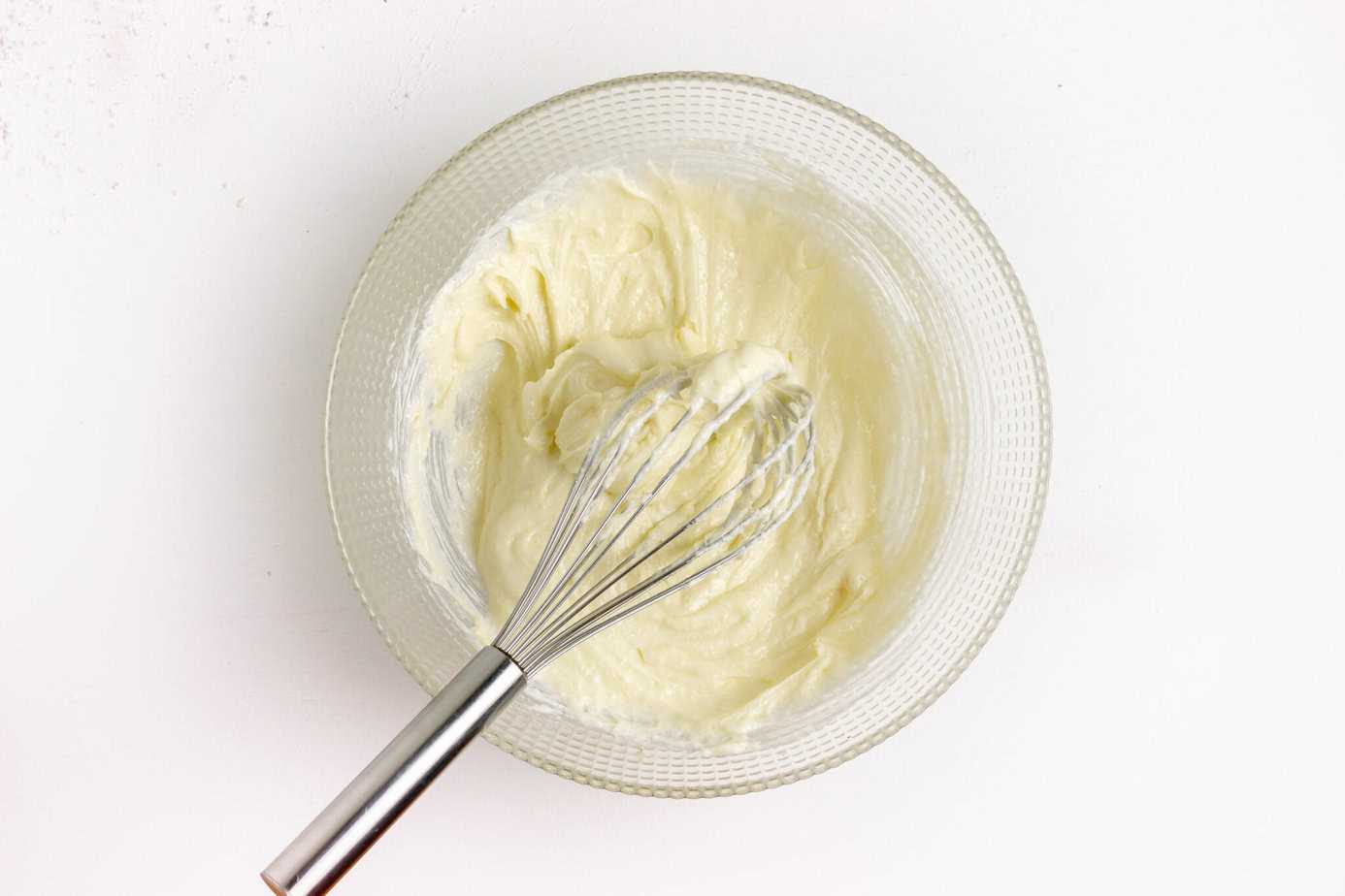 whisk in cheesecake batter in clear mixing bowl