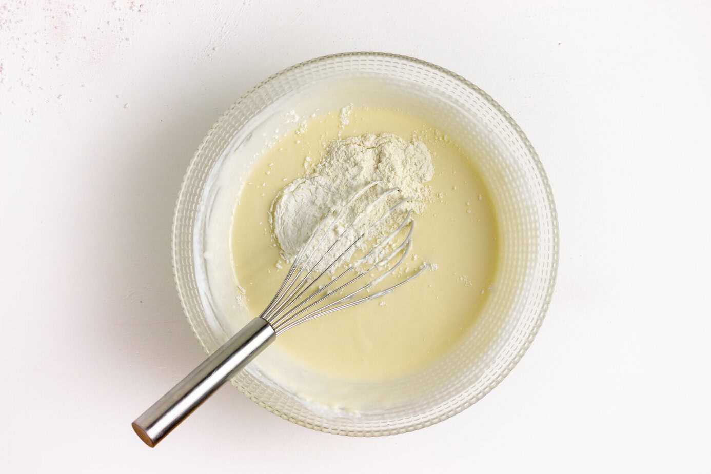 adding sour cream to cheesecake filling in mixing bowl