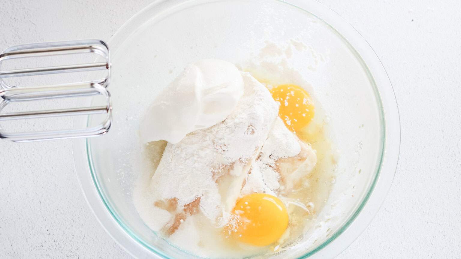 cheesecake ingredients in a clear mixing bowl