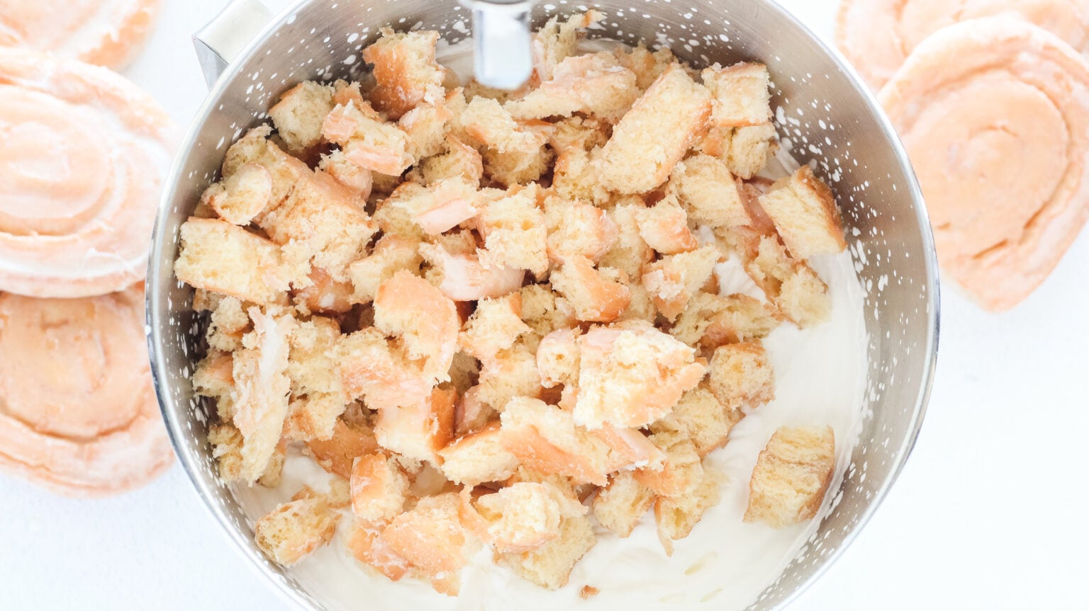 honey bun pieces in mixing bowl with whipped cream and condense milk
