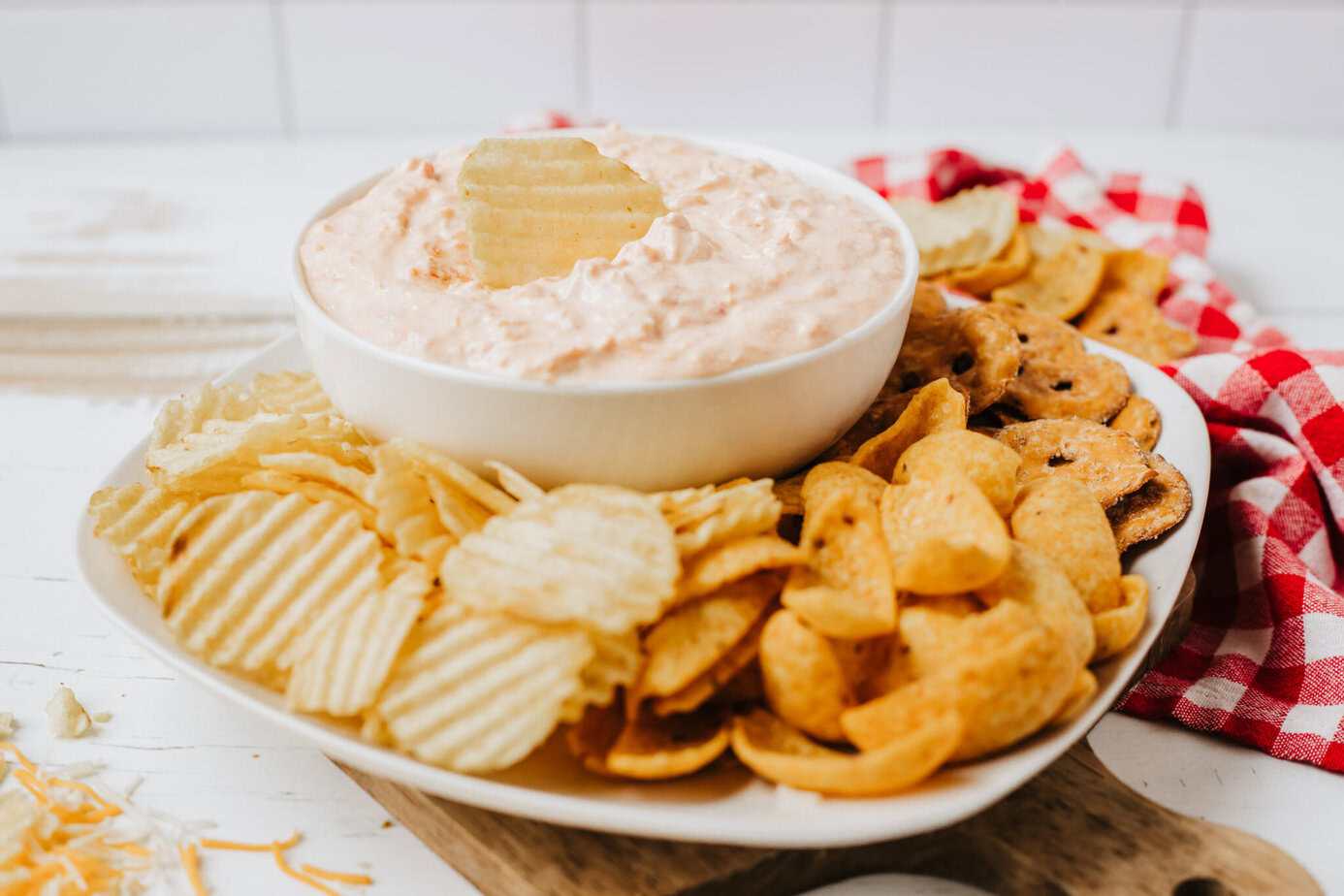 boat dip on a platter surrounded by chips