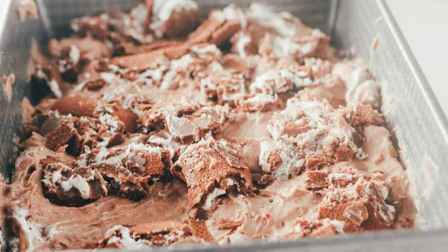 crumbled swiss rolls on top of ice cream mix