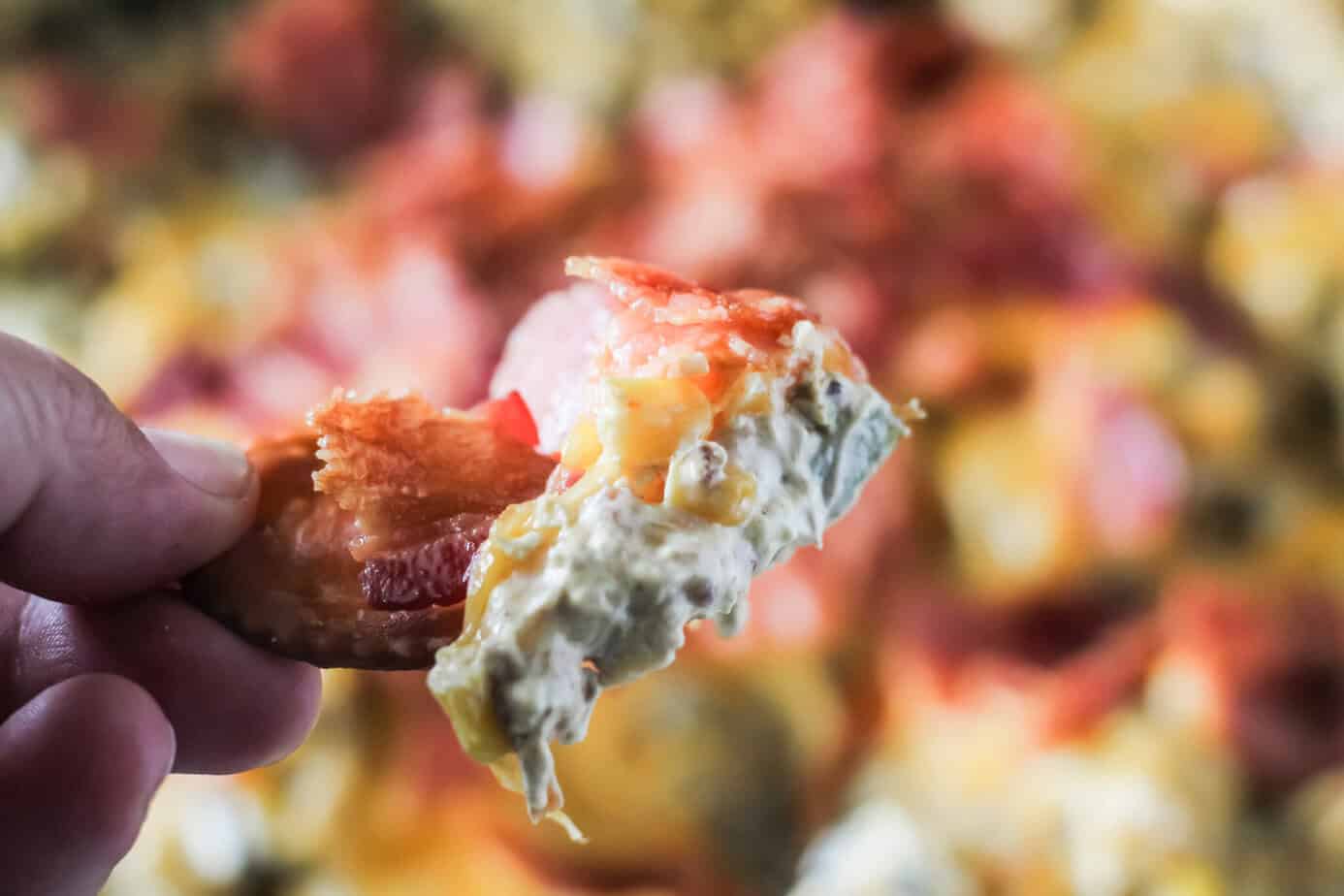 dipping fiesta dip with a cracker