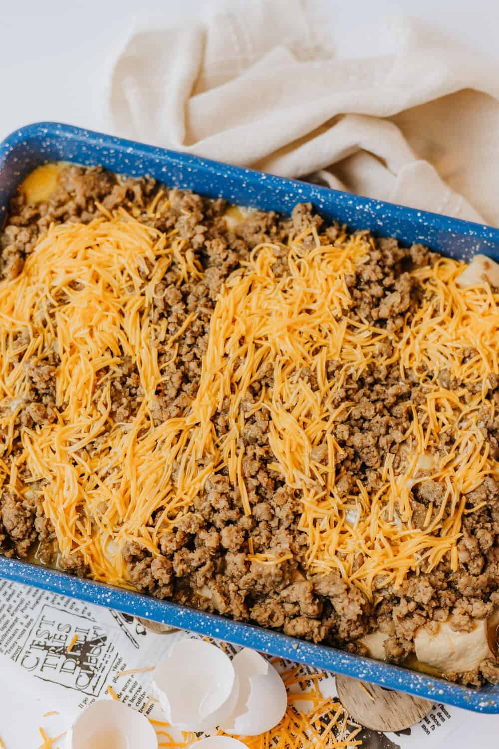 eggs and cheese poured over sausage and biscuits
