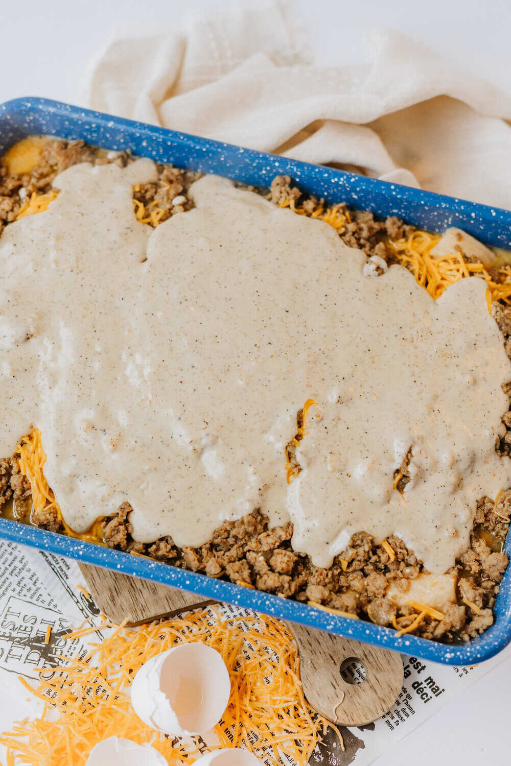 gravy poured over other layers of biscuits, eggs, cheese and sausage gravy
