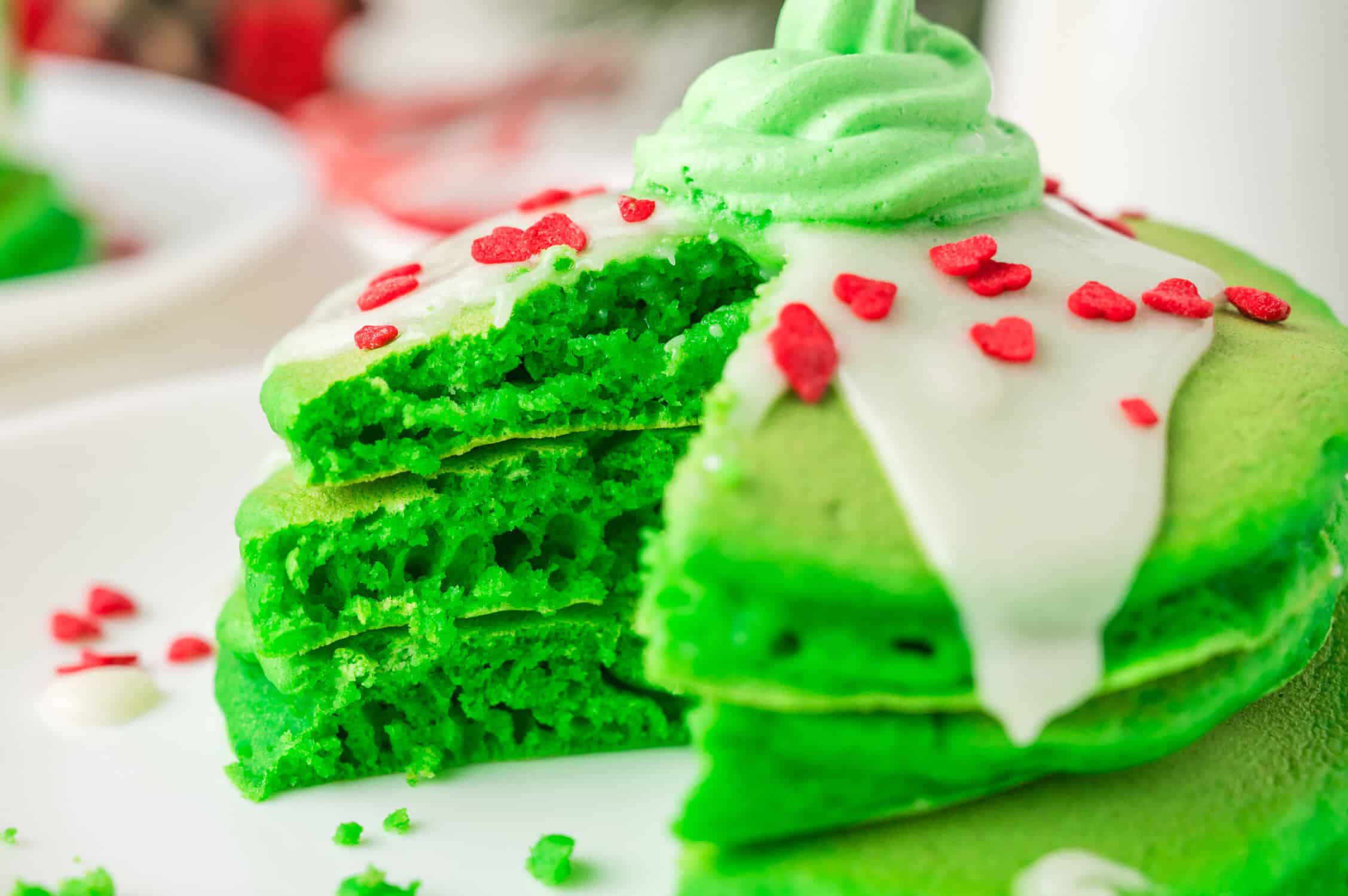 grinch pancakes with cream cheese glaze and green whipped cream