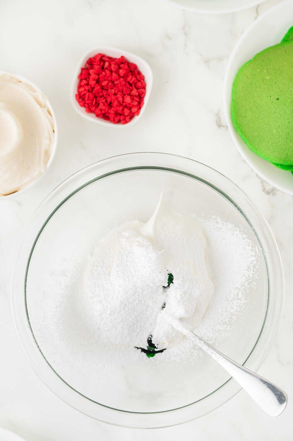 adding green food coloring to sweetened Cool Whip