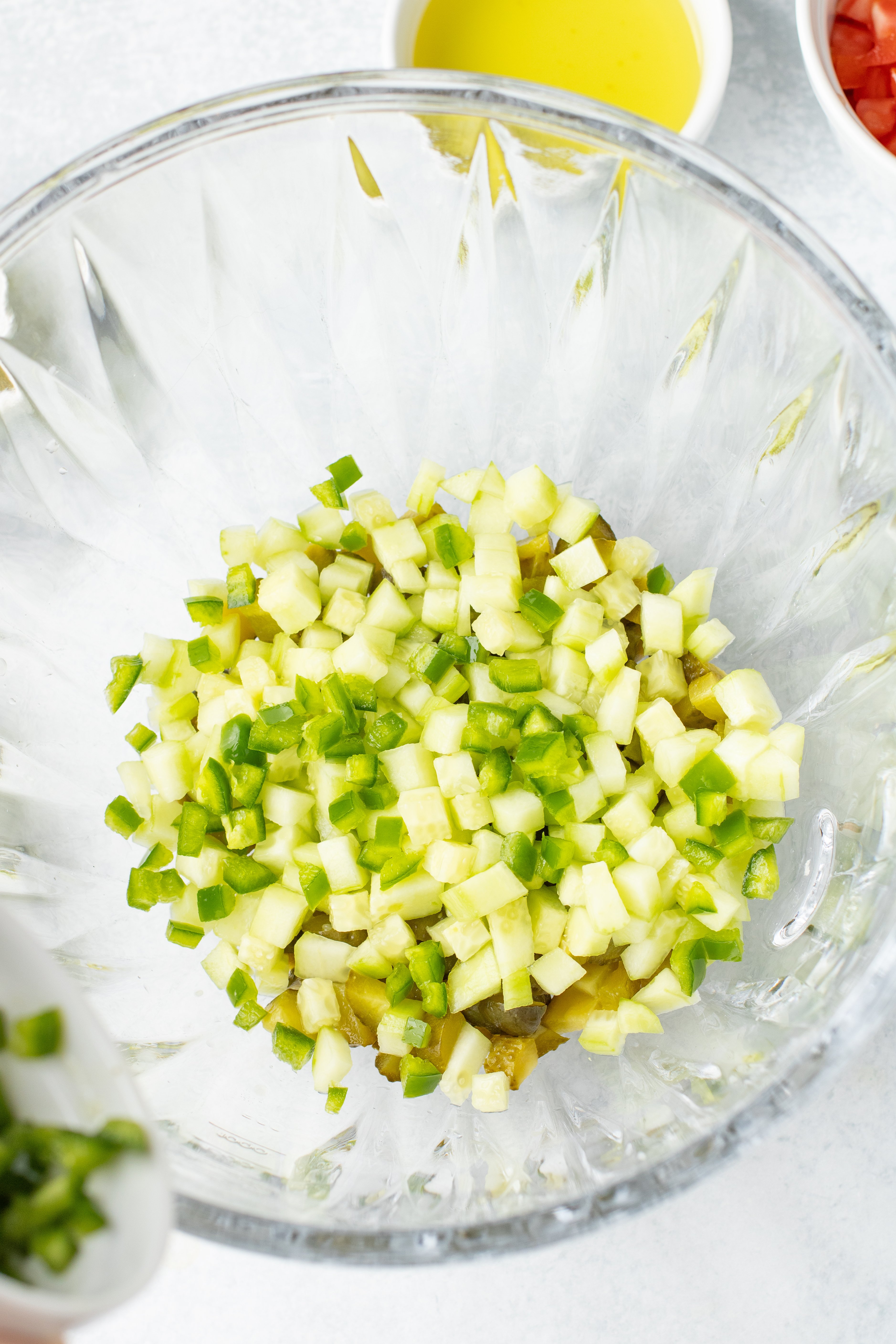 fresh diced jalapeno added to bowl with pickles and cucumbers
