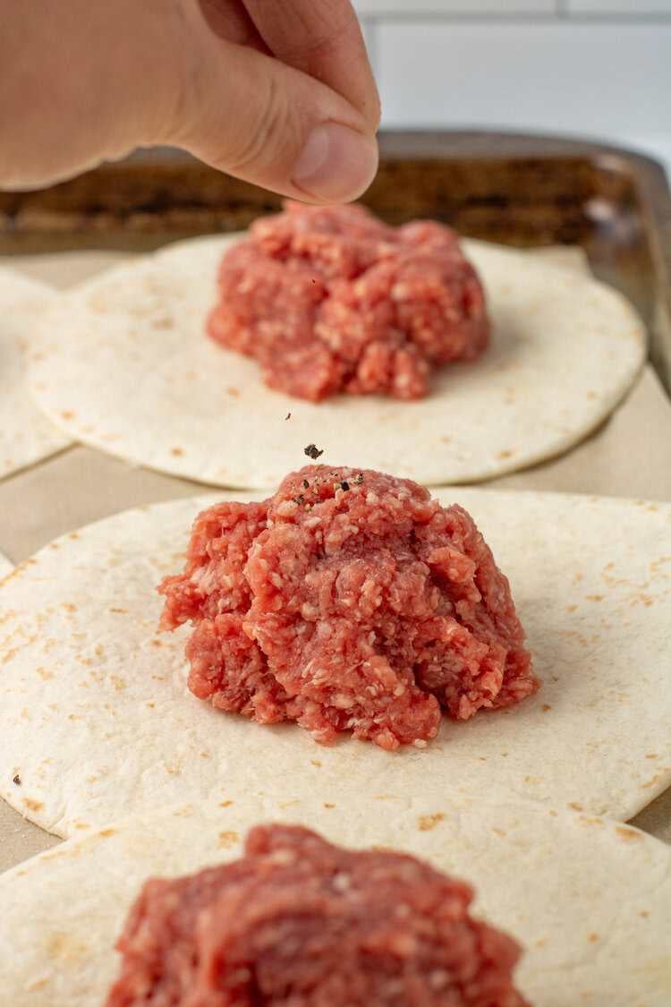 sprinkling salt and pepper on ground beef