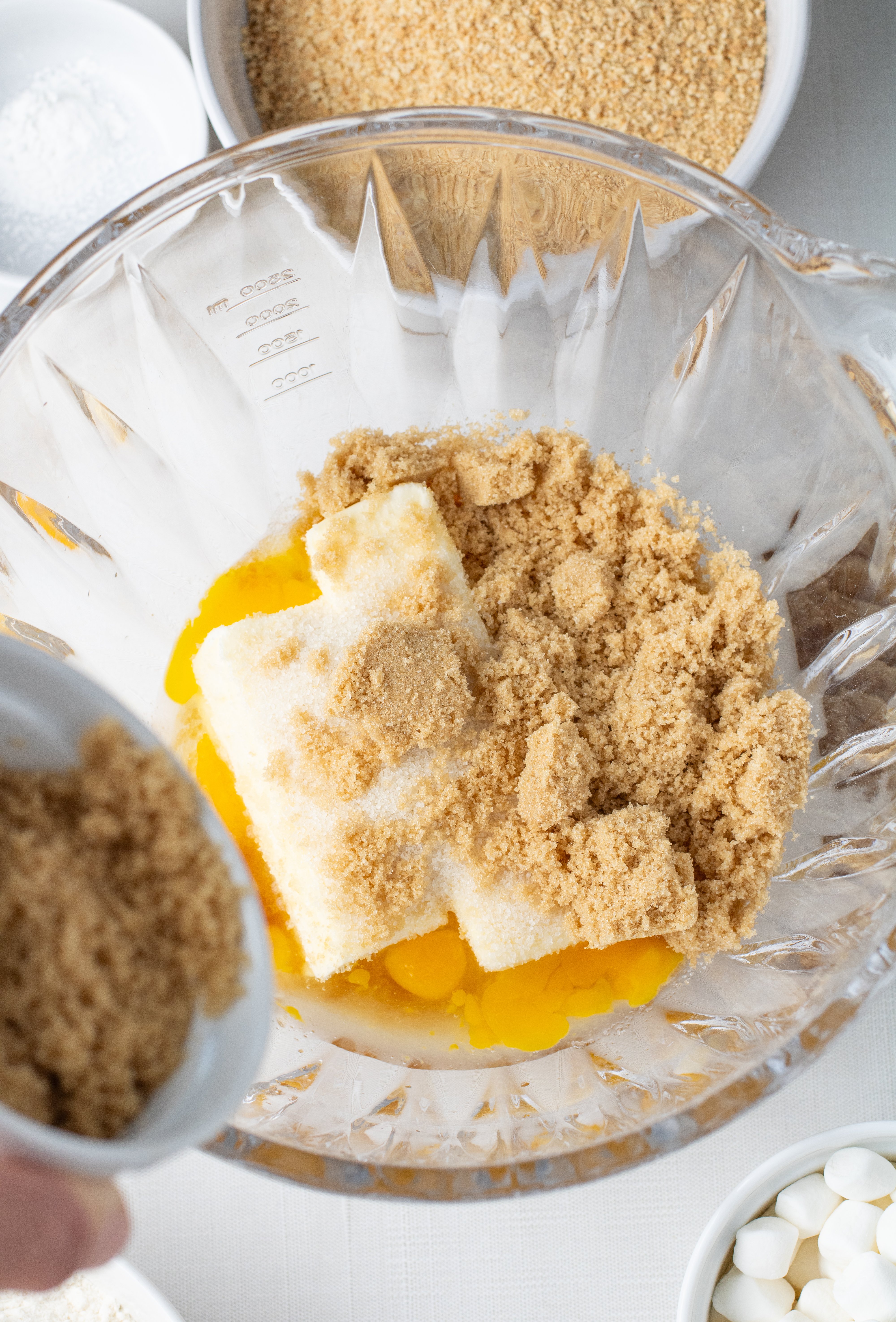adding brown sugar to the mixing bowl