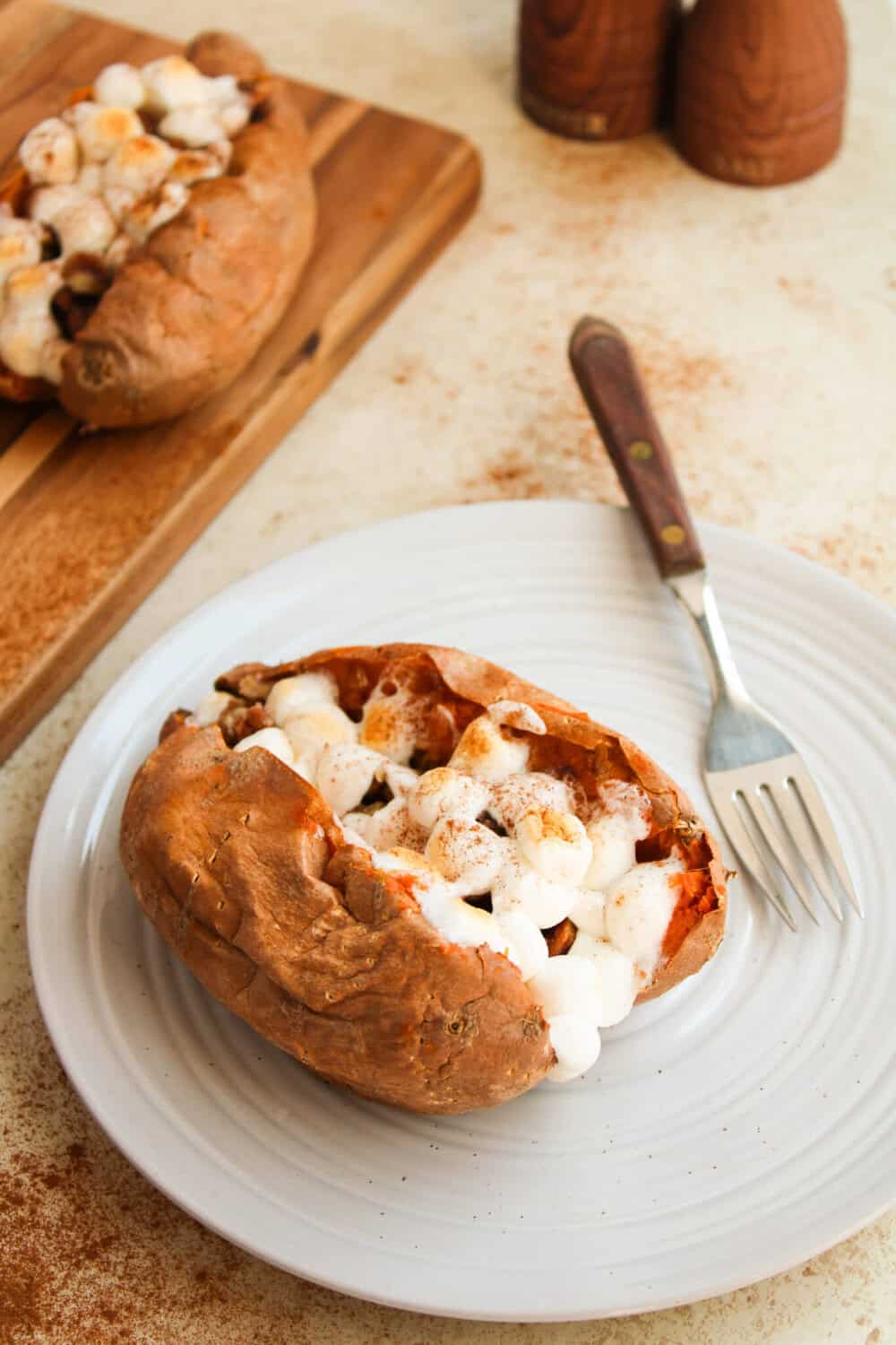 Baked sweet potato split in half with mini marshmallows on top.