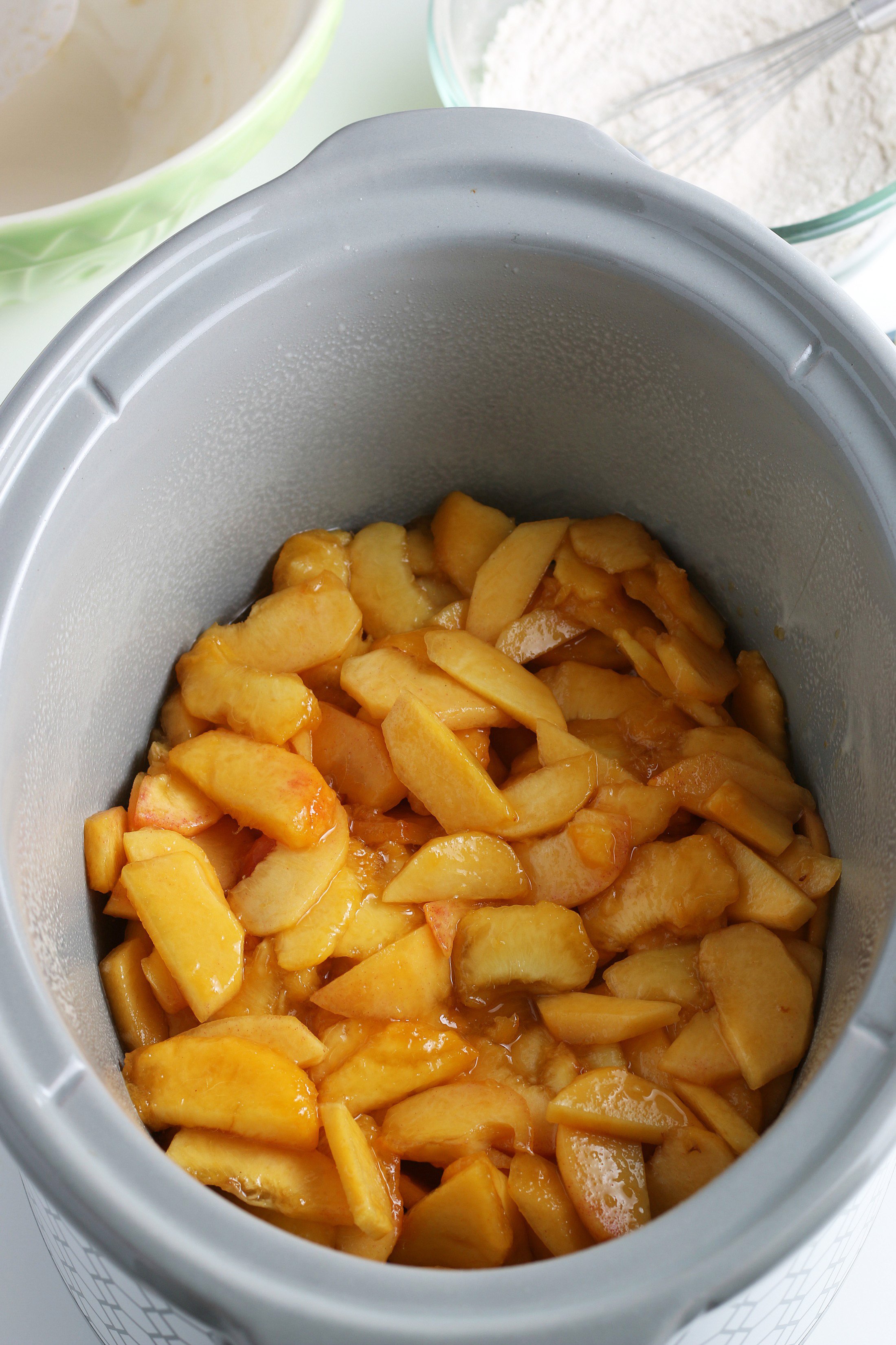 peaches in the bottom of a crockpot dish