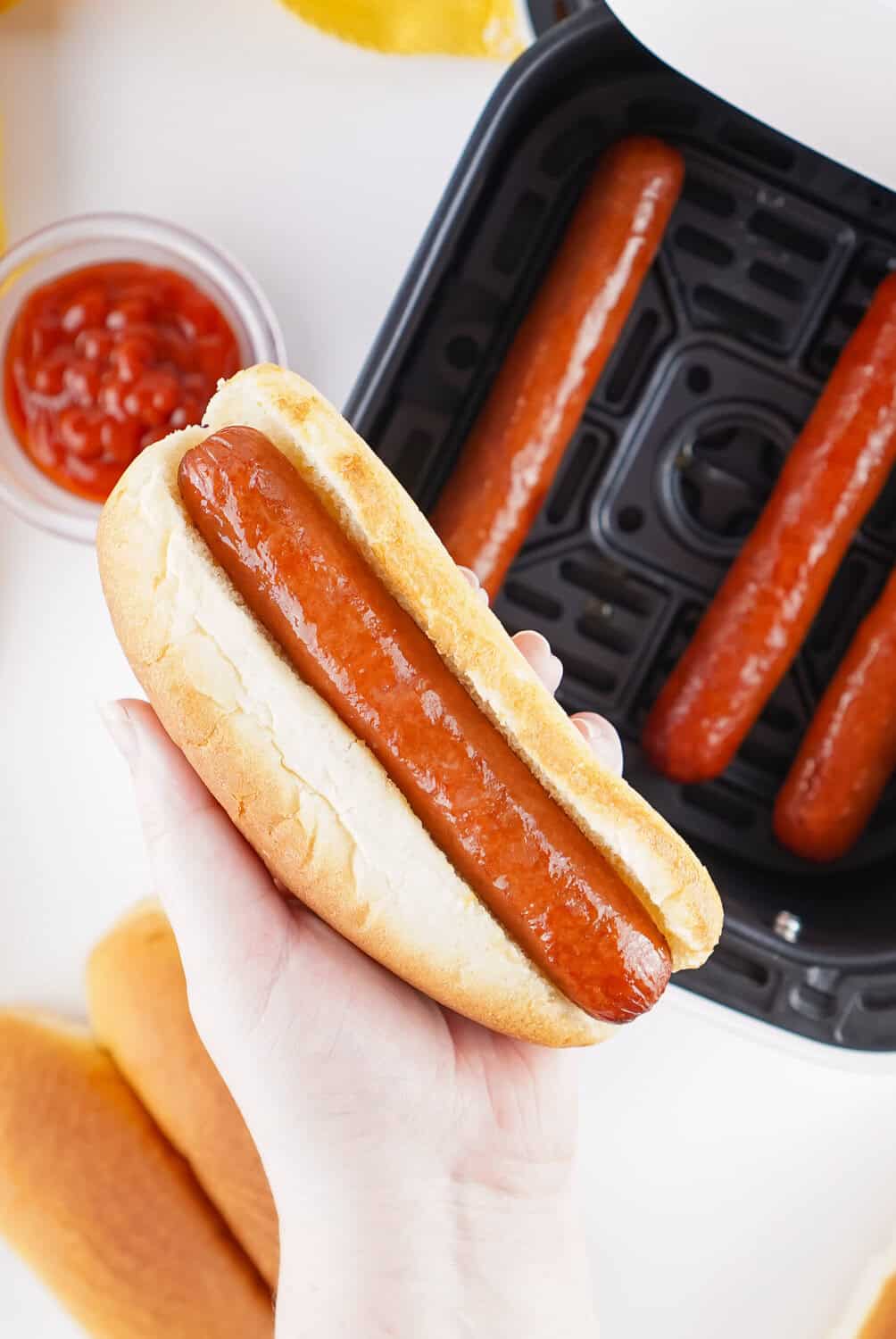 putting air fryer hot dog in a bun
